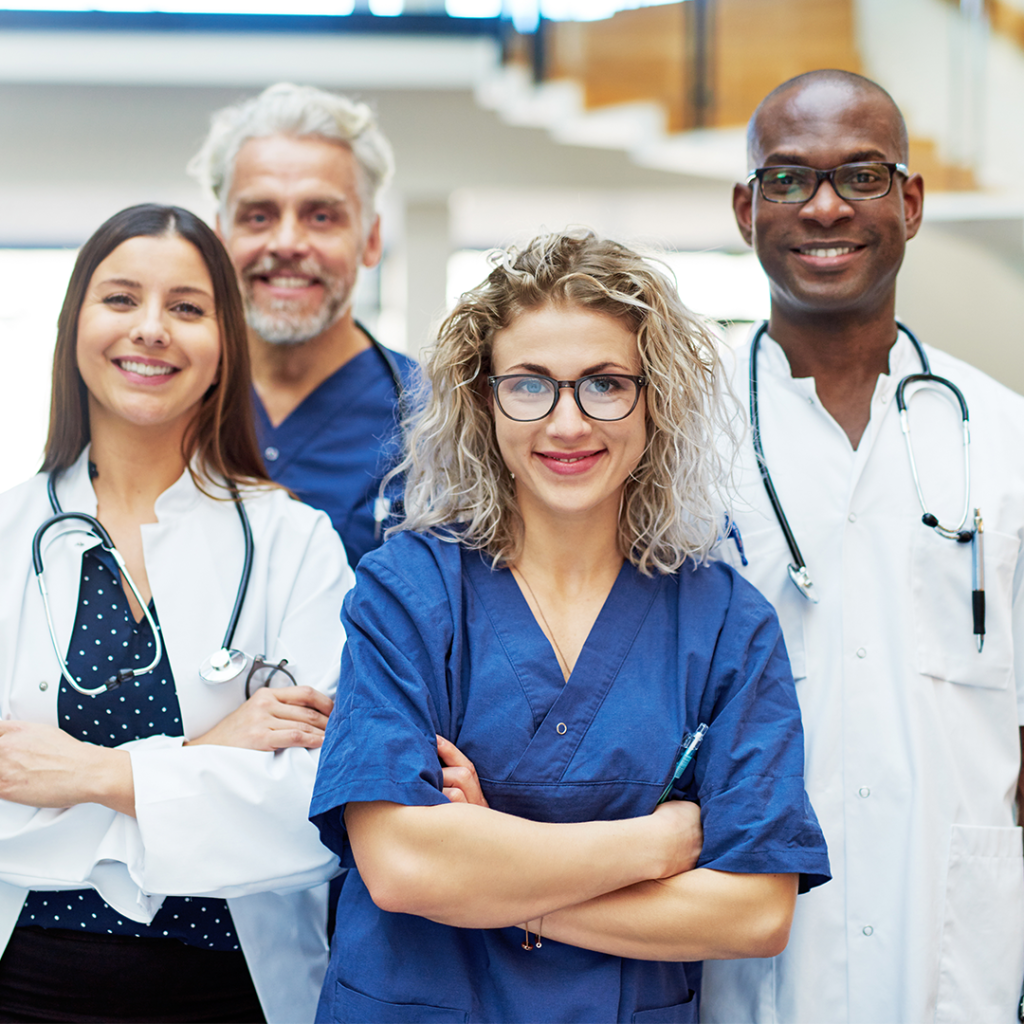 Four doctors smiling at the camera. Happy to help their patients.