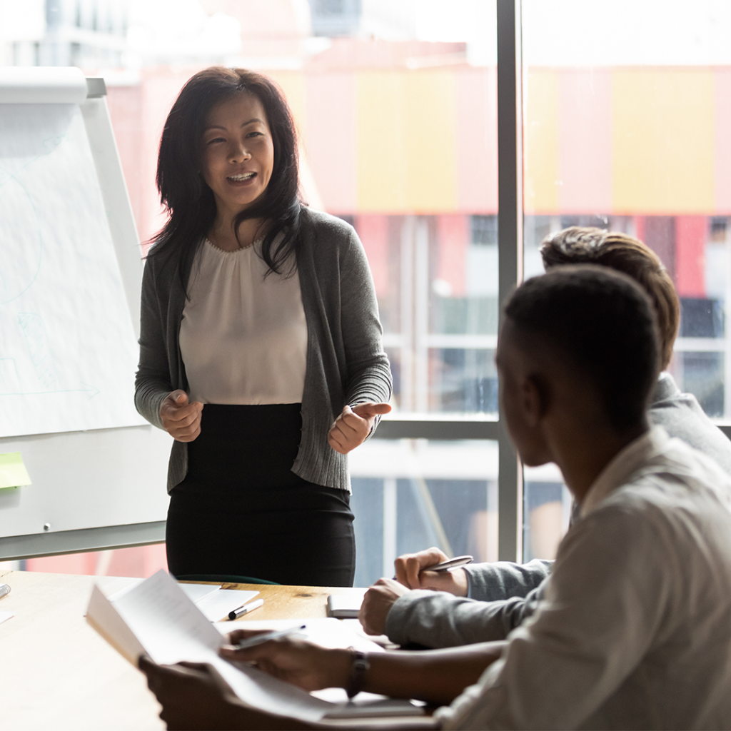 Female business woman leads a team meeting at a conference table.