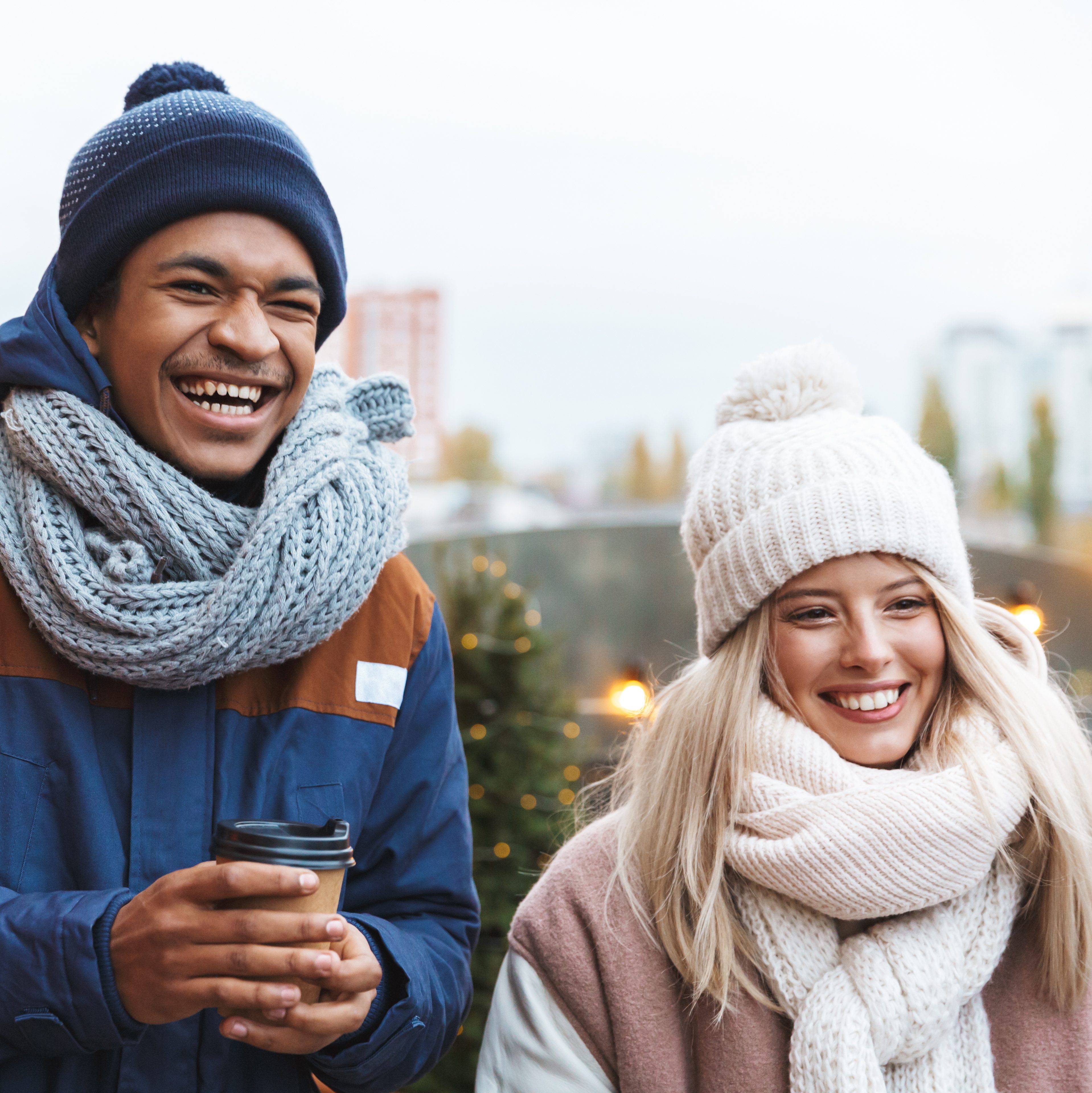 Young friends standing in a circle talking with each other in winter town square.