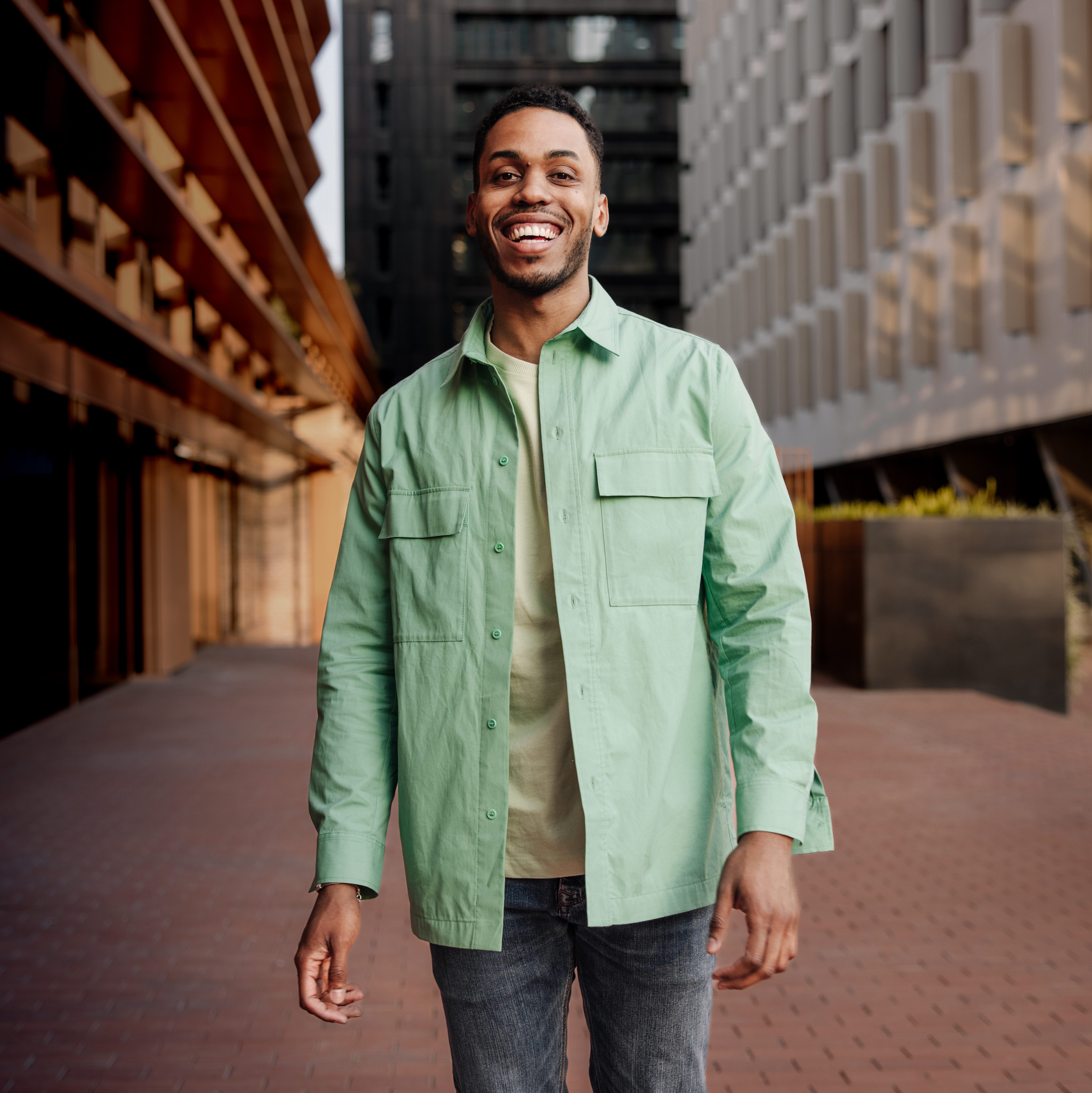 A male walks down an urban street.