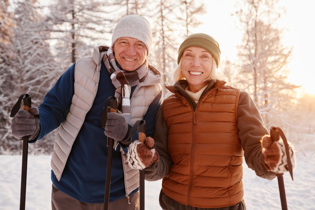 Senior couple cross country skiing in the snow.