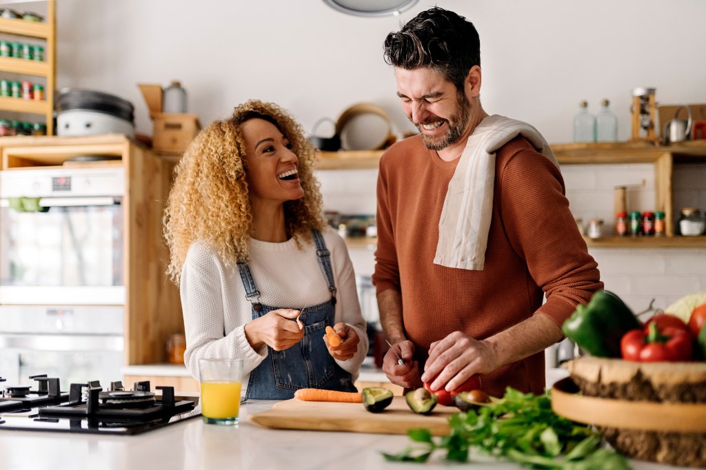 A couple cooks breakfast together in their kitchen.