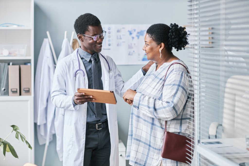 A young doctor consulting a female in a medical office.